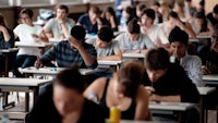 a group of people sitting at desks in a classroom