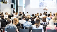 a group of people in a conference room watching a presentation