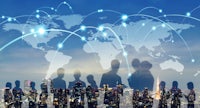 silhouettes of business people standing in front of a world map