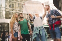 a group of friends looking at a map on the street