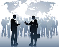 silhouettes of business people talking in front of a world map